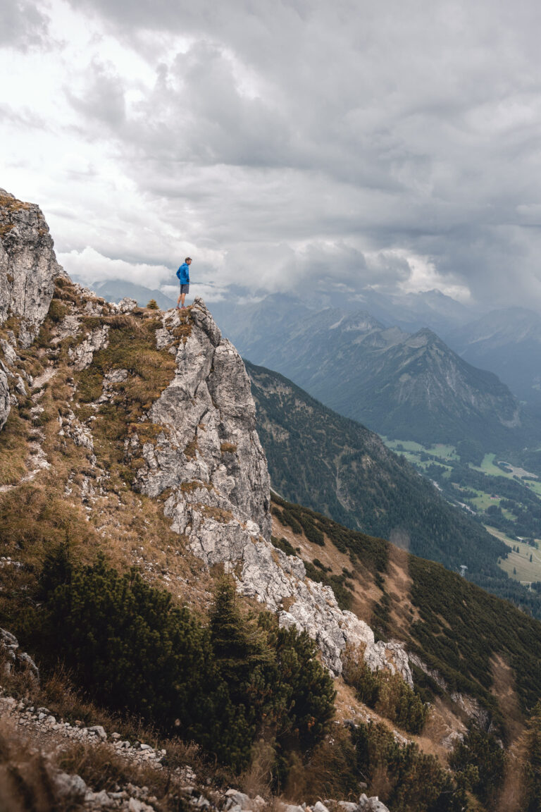 Florian Reichert steht auf einem kleinen Felsvorsprung - Outdoorfotografie Chris Gollhofer - Süddeutschland