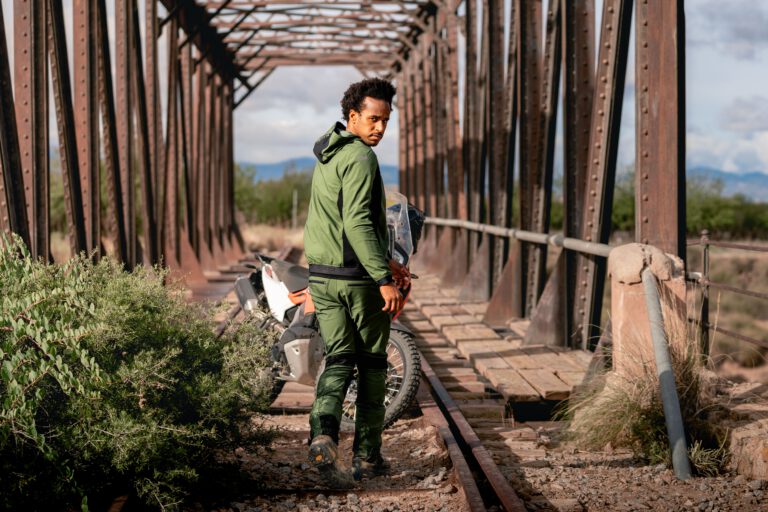 Ein Mann auf einem alten Bahngleis schaut über die rechte Schulter in die Kamera - Chris Gollhofer Fashion Fotograf - Andalusien